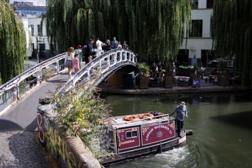 epa13188611 People cross a pedestrian bridge by the canals as they visit Camden Town in north London, Britain, 24 August 2026. Camden Town is one of LondonÕs most culturally significant neighbourhoods, renowned for its alternative music, arts and fashion scene and its long-standing influence on British youth culture.  EPA/TOLGA AKMEN