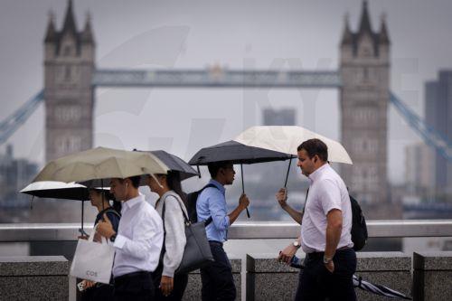 epa13194103 Commuters holding umbrellas cross London Bridge during heavy rainfall in London, Britain, 27 August 2026. The heavy rain forecast comes as 71 percent of England and all of Wales remain officially in drought, even as the Met Office issues thunderstorm warnings across the country with up to a month’s worth of rain potentially falling on parched...