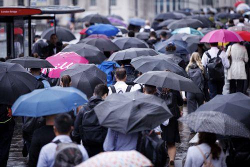 epa13194109 Commuters holding umbrellas cross London Bridge during heavy rainfall in London, Britain, 27 August 2026. The heavy rain forecast comes as 71 percent of England and all of Wales remain officially in drought, even as the Met Office issues thunderstorm warnings across the country with up to a month’s worth of rain potentially falling on parched...