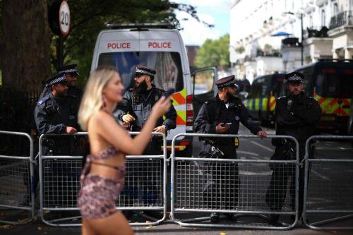 epa13202245 A reveller walks past a police barrier as people attend the Notting Hill Carnival adults' parade in London, Britain, 31 August 2026. The carnival, marking its 60th year, is Europe's largest street carnival, celebrating Caribbean history and culture, and runs from 30 August to 31 August 2026.  EPA/TOLGA AKMEN