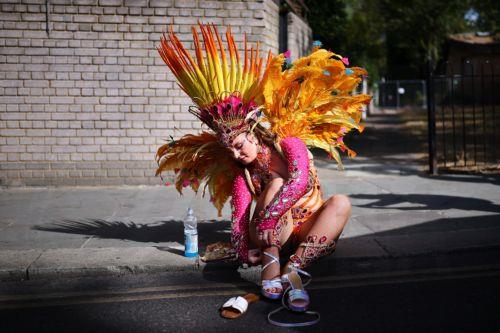 epa13202252 A costumed participant gets ready to perform during the Notting Hill Carnival adults' parade in London, Britain, 31 August 2026. The carnival, marking its 60th year, is Europe's largest street carnival, celebrating Caribbean history and culture, and runs from 30 August to 31 August 2026.  EPA/TOLGA AKMEN