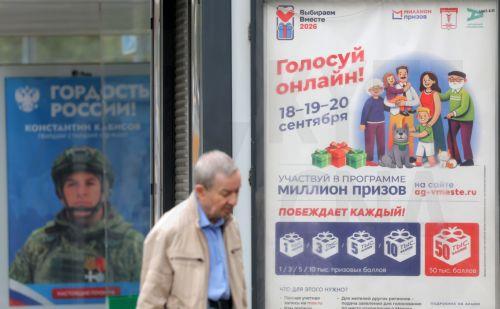 epa13202297 A man walks in front of a billboard announcing the upcoming parliamentary elections (R) and a billboard in support of the Russian Armed Forces, showing a Russian soldier, in Moscow, Russia, 31 August 2026. Parliamentary elections in Russia are scheduled for 18 to 20 September 2026.  EPA/MAXIM SHIPENKOV