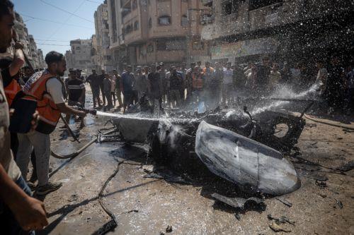 epa13202350 Palestinians inspect a destroyed car following an Israeli air strike on Gaza City, 31 August 2026. According to reports by the Ministry of Health in Gaza, at least three Palestinians were killed in the Israeli attack.  EPA/MOHAMMED SABER