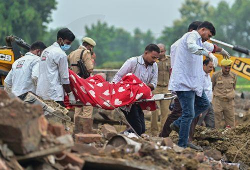 epa13202390 Indian health workers carry the mortal remains of a victim as they perform rescue work at a site after an explosion in a firecracker factory in Pipri, Uttar Pradesh state, India, 31 August 2026. The explosion in the  firecracker factory killed more than five people and several injured, according to official sources. The explosion also damaged...