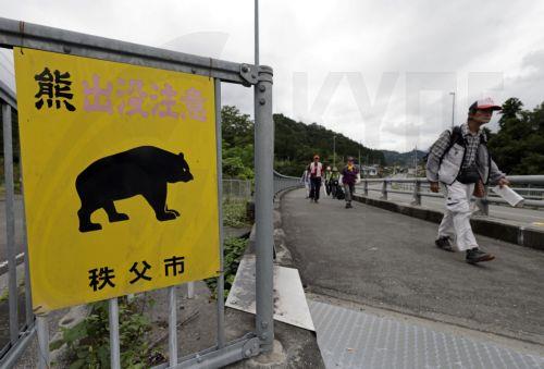 epa13238474 People walk past a sign reading 'Beware of Bears' in Chichibu, Saitama prefecture, northeast of Tokyo, Japan, 09 September 2026 (issued 14 September 2026). Suzukaen, a restaurant specializing in game meat, is one of the few establishments in Japan to feature bear on its menu, amid unprecedented rise in bear attacks.  EPA/FRANCK ROBICHON