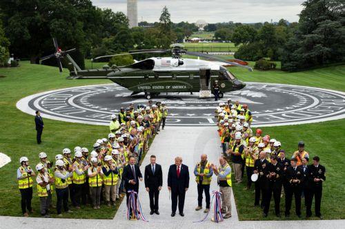 epa13254960 US President Donald Trump (C) is joined by Jared Oldroyd, division president of Clark Construction, and Jim Taiclet, chairman and chief executive officer of Lockheed Martin Corp., during a ribbon-cutting ceremony for a new helipad on the South Lawn of the White House in Washington, DC, USA, 21 September 2026 (issued 22 September 2026). The new...