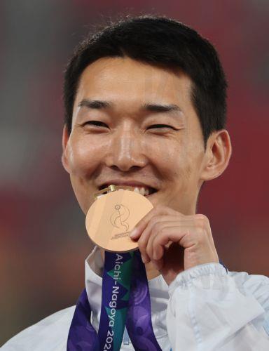 epa13267429 Woo Sang-hyeok of South Korea bites his bronze medal during the medal ceremony after finishing third in the men's high jump final at the Aichi-Nagoya 2026 Asian Games in Nagoya, Japan, 27 September 2026 (issued 28 September 2026).  EPA/YONHAP SOUTH KOREA OUT