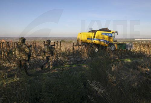epa13277314 Ukrainian servicemen guard farmers from Russian drones as they harvest sunflowers near a frontline in the Zaporizhzhia region, Ukraine, 02 October 2026, amid the ongoing Russian invasion. The territory close to the frontline is extremely dangerous due to Russian FPV drones.  EPA/OLEG MOVCHANIUK