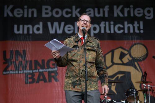 epa13277394 Member of European Parliament Martin Sonneborn speaks during a protest against compulsory military service at the Brandenburg Gate in Berlin, Germany, 02 October 2026.  EPA/CLEMENS BILAN