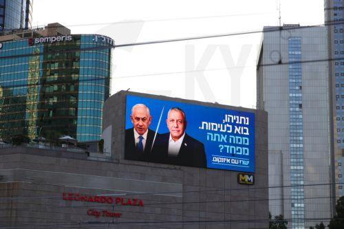 epa13283971 A large election billboard shows Israeli Prime Minister Benjamin Netanyahu (C-L) and leader of the Yashar party, Gadi Eisenkot (C-R), with a message in Hebrew stating 'Netanyahu, come to a debate; what are you afraid of?' in Tel Aviv, Israel, 06 October 2026. Israel will hold elections on 27 October.  EPA/ABIR SULTAN EPA