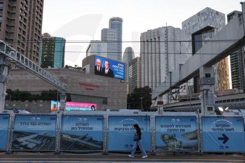 epa13283974 A large election billboard (top) shows Israeli Prime Minister Benjamin Netanyahu (C-L) and leader of the Yashar party, Gadi Eisenkot (C-R), with a message in Hebrew stating 'Netanyahu, come to a debate; what are you afraid of?' in Tel Aviv, Israel, 06 October 2026. Israel will hold elections on 27 October.  EPA/ABIR SULTAN EPA