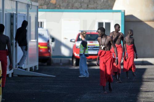 epa13315100 Sub-Saharan migrants, who were rescued by the Rescue Navy while attempting to reach Spain, wait to get assistance from Red Cross members, at La Restinga dock in El Hierro, Canary Islands, Spain, 19 October 2026. A total of 145 Sub-Saharan migrants were rescued off the shore while attempting to reach Spain.  EPA/Gelmert Finol