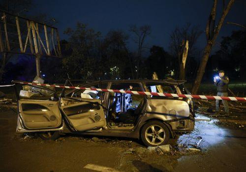 epa13333630 People look at a damaged car at the site of a Russian missile strike on a road in a residential area in Kyiv, Ukraine, 27 October 2026, amid the ongoing Russian invasion. At least one person died, and 10 others were injured during the overnight Russian ballistic missile attack, according to the State Emergency Service report.  EPA/SERGEY...