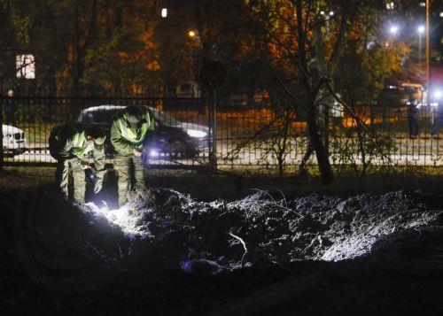 epa13333634 Ukrainian officials inspect a crater at the site of a Russian missile strike on a residential area in Kyiv, Ukraine, 26 October 2026, amid the ongoing Russian invasion. At least one person died, and 10 others were injured during the overnight Russian ballistic missile attack, according to the State Emergency Service report.  EPA/SERGEY DOLZHENKO