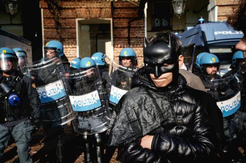 epa13341495 A masked protester poses in front of policemen during a demonstration and a general strike organized by the USB trade union in Turin, Italy, 30 October 2026. Workers and students protest against war, the economic situation, and the rising cost of living.  EPA/TINO ROMANO