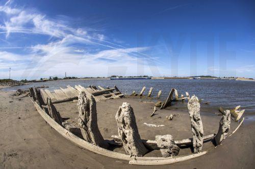 epa10104284 An inland vessel passes the wreck of the dynamite ship Elisabeth, which exploded in 1895 and has become visible due to the low water level in the Rhine near the Dutch-German border at Spijk and Tolkamer, at Griethausen, the Netherlands, 03 August 2022. Shipping on all major rivers except the Meuse suffers from reduced navigation depths because...