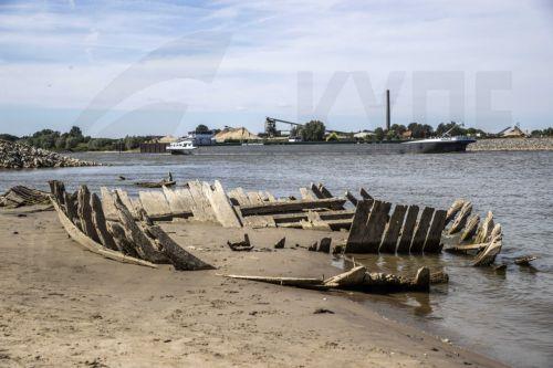 epa10104285 An inland vessel passes the wreck of the dynamite ship Elisabeth, which exploded in 1895 and has become visible due to the low water level in the Rhine near the Dutch-German border at Spijk and Tolkamer, at Griethausen, the Netherlands, 03 August 2022. Shipping on all major rivers except the Meuse suffers from reduced navigation depths because...