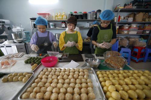 epa10139410 Workers make mooncakes at a bakery in Hanoi, Vietnam 26 August 2022. Mid-Autumn Festival, also known as Moon Festival, is a special festival for Vietnamese children as the celebrations involving lion dance, lantern processions and mooncakes. This year the festival falls on 10 September.  EPA/LUONG THAI LINH