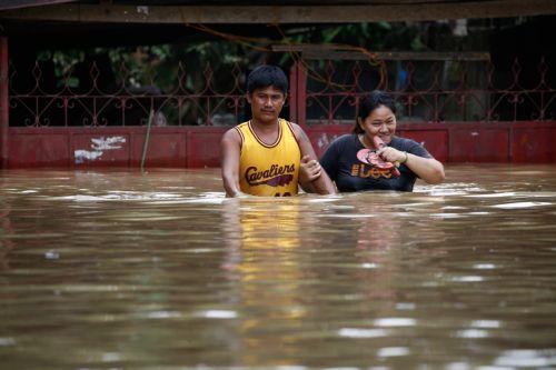 epa10206727 Residents wade through flood water caused by typhoon Noru in San Miguel town of Bulacan province, north of Manila, Philippines 26 September 2022. Typhoon Noru crossed the northern Philippine region of Luzon on 25 September and prompted thousands to evacuate due to heavy rain and strong winds. Typhoon Noru is expected to leave the Philippine area...