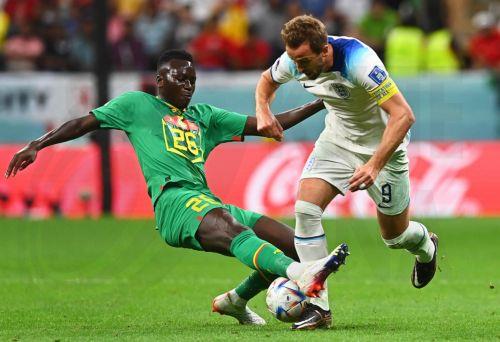 epa10348862 Harry Kane (R) of England in action against Pape Gueye (L) of Senegal during the FIFA World Cup 2022 round of 16 soccer match between England and Senegal at Al Bayt Stadium in Al Khor, Qatar, 04 December 2022.  EPA/Neil Hall