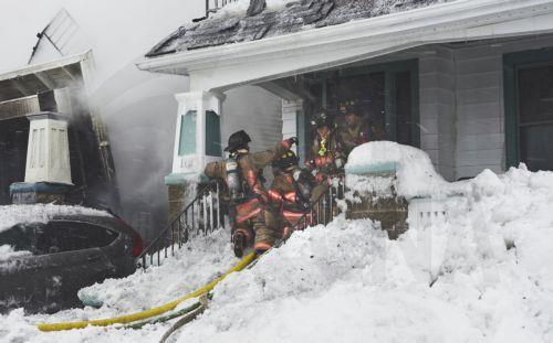 epa10378756 Firefighters work to extinguish a house fire on Lonsdale Road as the area continues to deal with the effects of a massive winter storm which has affected large portions of the United States, continues in Buffalo, New York, USA, 26 December 2022. Much of the United States experienced some sort of winter weather this week as result of the large...