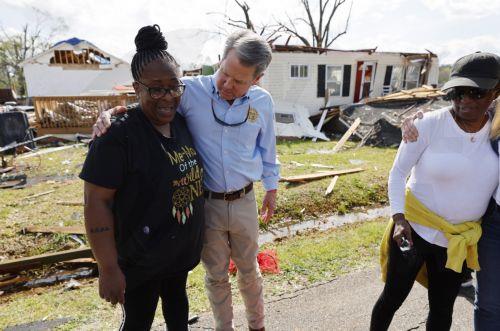 epa10546223 Georgia Governor Brian Kemp (C) speaks with residents as they tour damaged areas in the wake of a tornado in West Point, Georgia, USA, 27 March 2023. Tornadoes were confirmed in Georgia on 26 March two days after at least 25 people were killed in Mississippi after a tornado and severe weather outbreak on 24 March, according to the Mississippi...