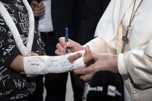 epa10553489 Pope Francis signs a young boy's cast as he leaves the Agostino Gemelli Hospital in Rome, Italy, 01 April 2023. The pope was hospitalized on 29 March following a respiratory infection and was discharged on 01 April.  EPA/ANGELO CARCONI