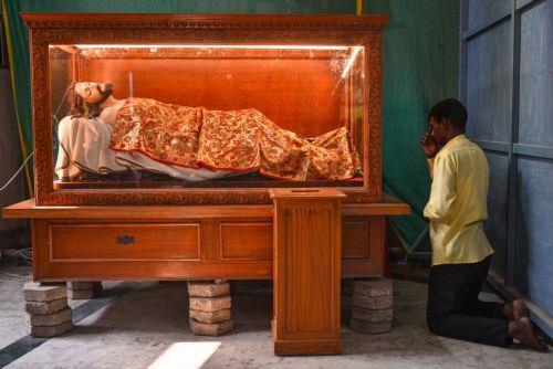 epa10555089 An Indian Christian offers a prayer in front of a statue of Jesus Christ during the Palm Sunday mass, at a church, in Chennai, India, 02 April 2023. Palm Sunday for Roman Catholic devotees symbolically marks the biblical account of the entry of Jesus Christ into Jerusalem, signaling the start of the Holy Week, prior to Easter.  EPA/IDREES...