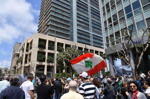 epa10617105 Lebanese Bank customers carry the national flag during a protest against the monetary policies organized by Depositors' Outcry, a group campaigning for the rights of depositors, outside of the cracker Prime minister Najib Mikati's residence in Beirut, Lebanon, 09 May 2023. Bank customers demand they be allowed to withdraw their savings, which...