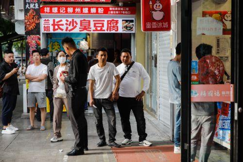 epa10617162 People stand beside a food street in Beijing, China, 09 May 2023. China's trade surplus surged to 90.21 billion dollars in April 2023, from 49.47 billion in the same period the prior year. Exports rose by 8.5 percent year on year, while imports fell by 7.9 percent as domestic demand weakened.  EPA/WU HAO