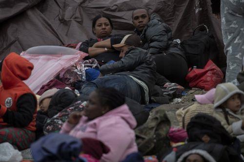 epa10624215 Stranded migrant families rest in the no man's land between the US and Mexico, in San Diego, California, USA, 12 May 2023. According to humanitarian volunteers, there are about 400 migrants, all families, held in the no man's land between Tijuana and San Diego after crossing the border. A significant increase in the number of migrants crossing...