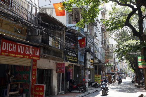 epa10630577 Vehicles move past utility poles with power cables in a street in Hanoi, Vietnam, 16 May 2023. Northern Vietnam is facing electricity shortages due to high demands amid the hot season, and decreased hydropower production, according to a report recently from Vietnam Electricity.  EPA/LUONG THAI LINH
