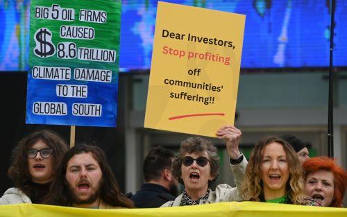 epa10647435 Demonstrators protest outside the Shell General Shareholders meeting at the Excel Centre in London, Britain, 23 May 2023. Scores of protesters managed to gain access to Shell's Annual General Meeting (AGM) before being carried or escorted out. Demonstrators are calling for Shell to be shut down stating the oil giant is a global pollutant. ...