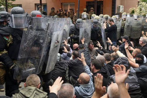 epaselect epa10662176 Ethnic Serbs sit on the street in front of the cordon of soldiers of NATO-led international peacekeeping Kosovo Force (KFOR) in front of the building of the municipality in Zvecan, Kosovo, 29 May 2023. Protests and clashes in Zvecan continue as tensions in northern Kosovoâ€™s region, with majority of ethnic Serbian people, arose after...