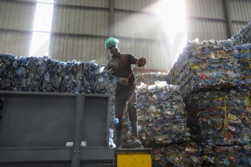 epa10674426 A worker prepares to load plastic bottles to be processed into flakes at the T3 EPZ Limited, a local company that recycles polyethylene terephthalate (PET) plastic bottles into PET flakes for export, on World Environment Day in Machakos, Kenya, 05 June 2023. The world marks the 2023 Environment Day on 05 June with a focus on 'solutions to...