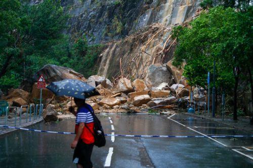 epaselect epa10847596 A man views the debris of a landslide blocking a road following torrential rains hitting the city, in Hong Kong, China, 08 September 2023. The government has stopped schools and several public services while bus services of a major operator have been suspended, amid a black rainstorm alert, the highest level of the city's weather...