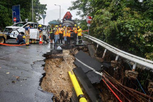epa10847744 Gas company workers inspect damage at a subsided road, following torrential rains hitting the city, in Hong Kong, China, 08 September 2023. The government has stopped schools and several public services while bus services of a major operator have been suspended, amid a black rainstorm alert, the highest level of the city's weather system. ...