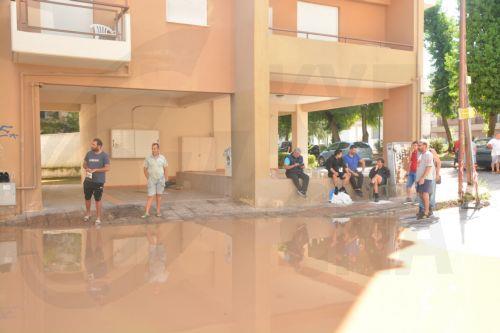 Κάτοικοι στέκονται μπροστά από πολυκατοικία δίπλα σε πλημμυρισμένο δρόμο σε παραποτάμια συνοικία, στη Λάρισα, την Παρασκευής 8 Σεπτεμβρίου 2023. Τα πλημμυρικά φαινόμενα άρχισαν να χτυπούν, από χθες αργά το βράδυ και την πόλη της Λάρισας, κυρίως τις συνοικίες που βρίσκονται κοντά στο Πηνειό Ποταμό, καθώς σημειώνεται υπερχείλιση των φρεατίων με μεγάλη...