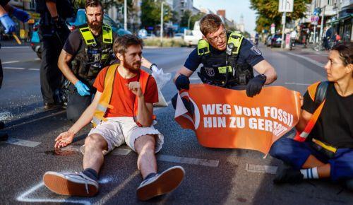 epa10867477 Activists of the Last Generation climate activism group block a street in Berlin, Germany, 18 September 2023. According to the climate activists, they will again start blocking streets at the capital to protest against the government's lack of plan and what they claim to be a 'breach of law' in the climate crisis.  EPA/HANNIBAL HANSCHKE