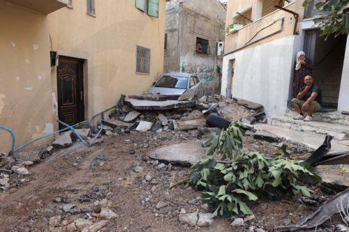 epa10879973 Residents look at a damaged house and car at the Nur Shams refugee camp near the West Bank city of Tulkarem, 24 September 2023, following a military operation by the Israeli Army earlier the same day. According to the Palestinian Health Ministry, two Palestinians were killed in the raid in which Israeli forces destroyed the main road and two...
