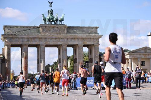 epa10880224 Runners participate in front of the Brandenburg Gate that still shoes signs if orange paint in the Berlin Marathon 2023 in Berlin, Germany, 24 September 2023.  In the morning of 17 September 2023, members of Last Generation climate activists, sprayed with prepared fire extinguishers, orange paint on the columns of the Berlin landmark Brandenburg...