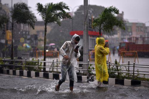 epa11010539 People wade through a flooded road during heavy rains as Cyclone Michaug is expected to make landfall on the eastern Indian coast, in Chennai, India, 04 December 2023. The Indian Meteorological Department has issued a red alert for heavy rains in Chennai as the cyclonic storm, 'Cyclone Michaung' is anticipated to make landfall between Andhra...