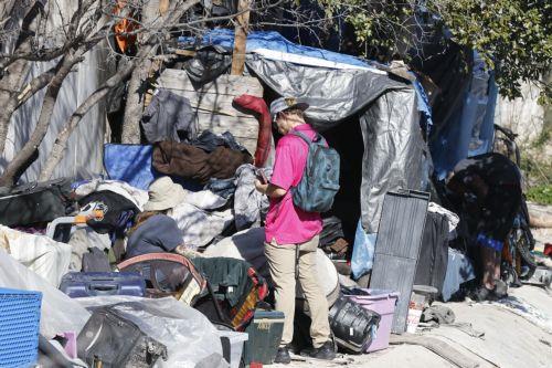 epa11113219 Homeless people sit in their encampment at the top of a basin of a river in Austin, Texas, USA, 29 January 2024. A report from Harvard's Joint Center for Housing on 25 January 2024, shows that homelessness in January 2023 has increased by 12 percent compared to last year, with over 650,000 people experiencing homelessness as a result of rising...