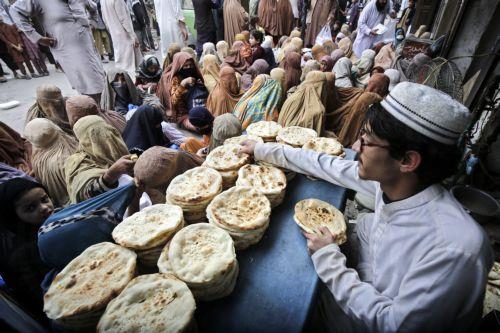 epa11229212 A man prepares free food to distribute to burqa-clad women to break their fast, during the fasting month of Ramadan in Peshawar, Pakistan, 19 March 2024. The Muslims' holy month of Ramadan is the ninth month in the Islamic calendar and it is believed that the revelation of the first verse in the Koran was during its last 10 nights. It is...