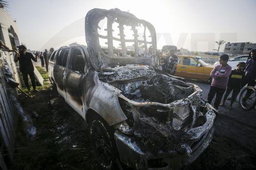 epa11255142 People stand near a destroyed car of the NGO World Central Kitchen (WCK) along Al Rashid road, between Deir Al Balah and Khan Younis in the southern Gaza Strip, 02 April 2024. According to the Palestinian Red Crescent, at least four people from the NGO World Central Kitchen (WCK) were killed when a missile hit their convoy in Deir al Balah while...