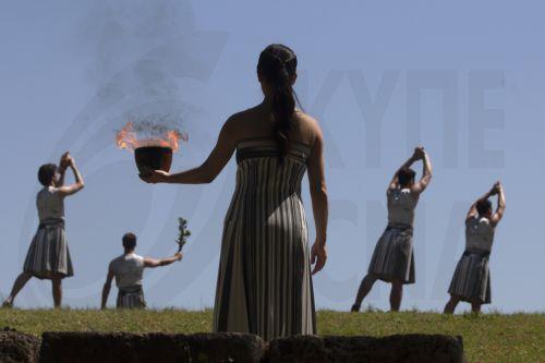 epa11279786 Greek actress Mary Mina (C) plays the role of High Priestess and holds the cauldron flame with the Olympic Flame during the rehearsal of the Olympic flame lighting ceremony for the Paris 2024 Summer Olympic Games, at the Ancient Olympia site in Peloponnese, southern Greece,15 April 2024. The Lighting ceremony of the Olympic Flame, ahead of the...