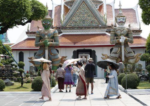 epa11321386 Tourists use umbrellas to protect themselves from sunlight amid hot weather at the Temple of Dawn, or Wat Arun, in Bangkok, Thailand, 06 May 2024. Thailand is facing a severe heatwave as the Thai Meteorological Department warned about the extremely hot weather with temperatures soaring to record highs over 44 degrees Celsius in some areas and...