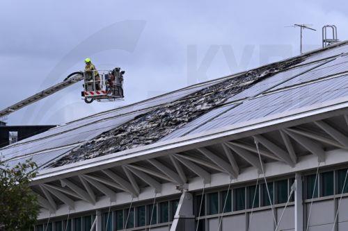 epa11336409 Members of Fire and Rescue NSW and other emergency responders work at the scene of a fire at Sydney Olympic Park Aquatic Centre in Sydney, Australia 13 May 2024. Fire-damaged solar panels can be seen on the roof of the swimming center which was home to the Aquatics competition during the Sydney 2000 Olympic Games.  EPA/DEAN LEWINS AUSTRALIA AND...
