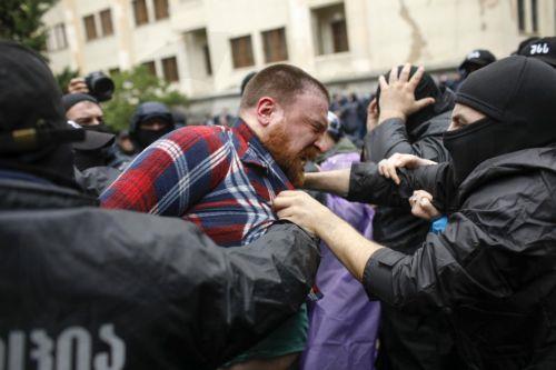 epaselect epa11336418 Georgian policemen detain an opposition party supporter during a rally against a draft bill on 'foreign agents' in downtown of Tbilisi, Georgia, 13 May 2024. Participants demand the repeal of the bill on 'foreign agents,' which will be considered in the third reading on May 13.  EPA/DAVID MDZINARISHVILI