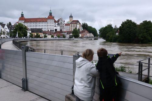 epa11387641 People watch the flooded Danube behind a safety fence in Neuburg an der Donau, Germany, 03 June 2024. Heavy rains caused flooding in Germany's southern states of Bavaria and Baden-Wuerttemberg.  EPA/ANNA SZILAGYI